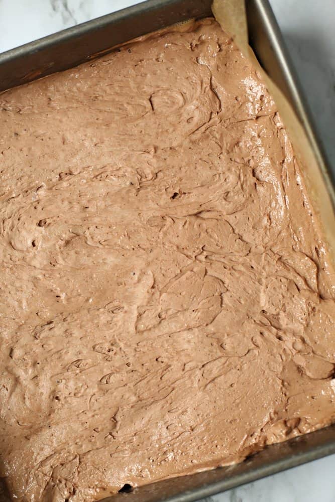 chocolate cheesecake batter spread on crushed graham cracker layer