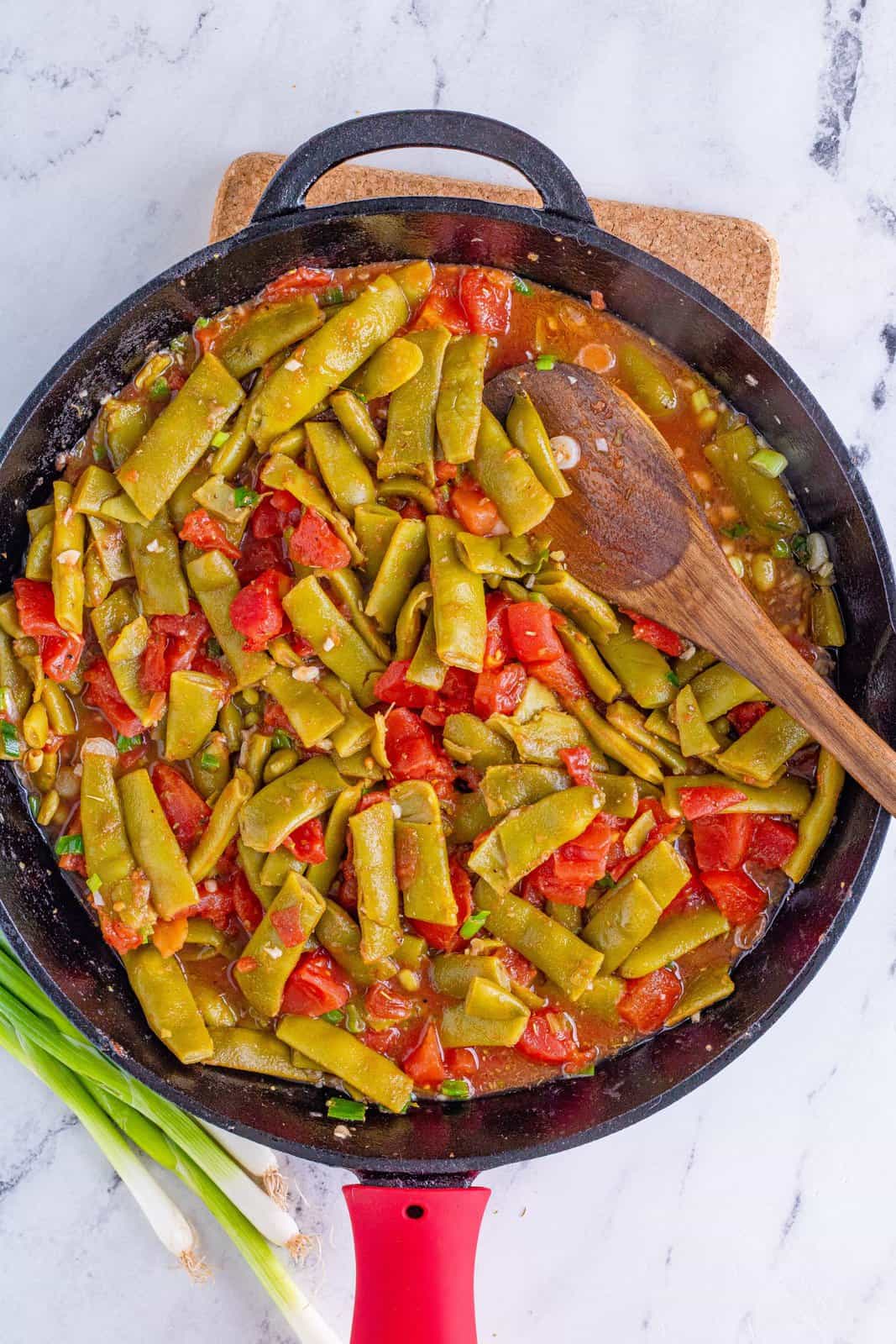 fully mixed green beans and diced tomatoes in the skillet. 