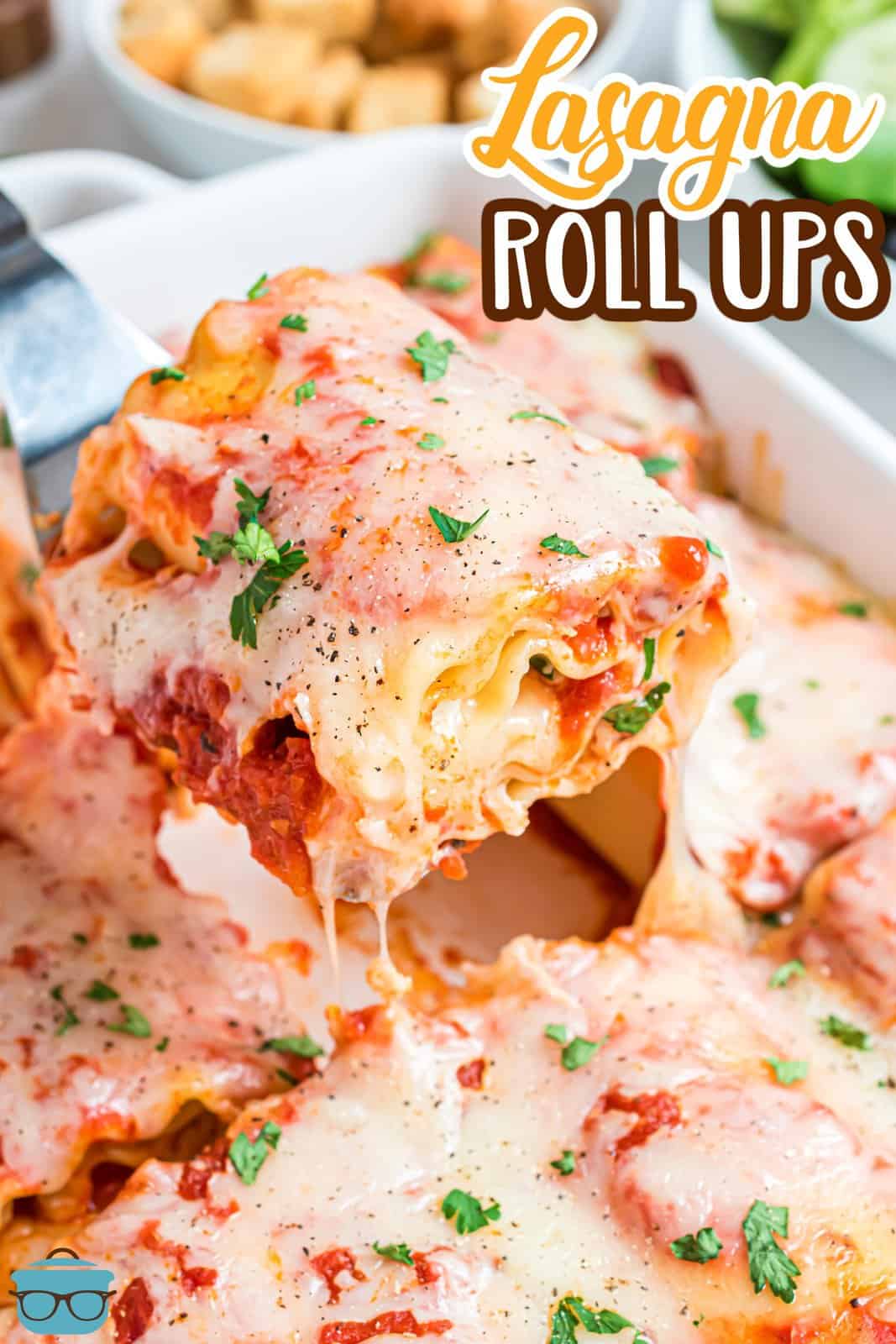 a spatula scooping up a lasagna rollup out of the baking dish.