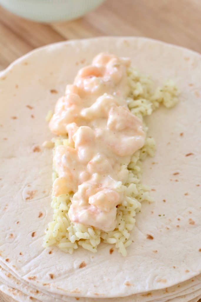 cream and shrimp on top of cilantro lime rice on a flour tortilla