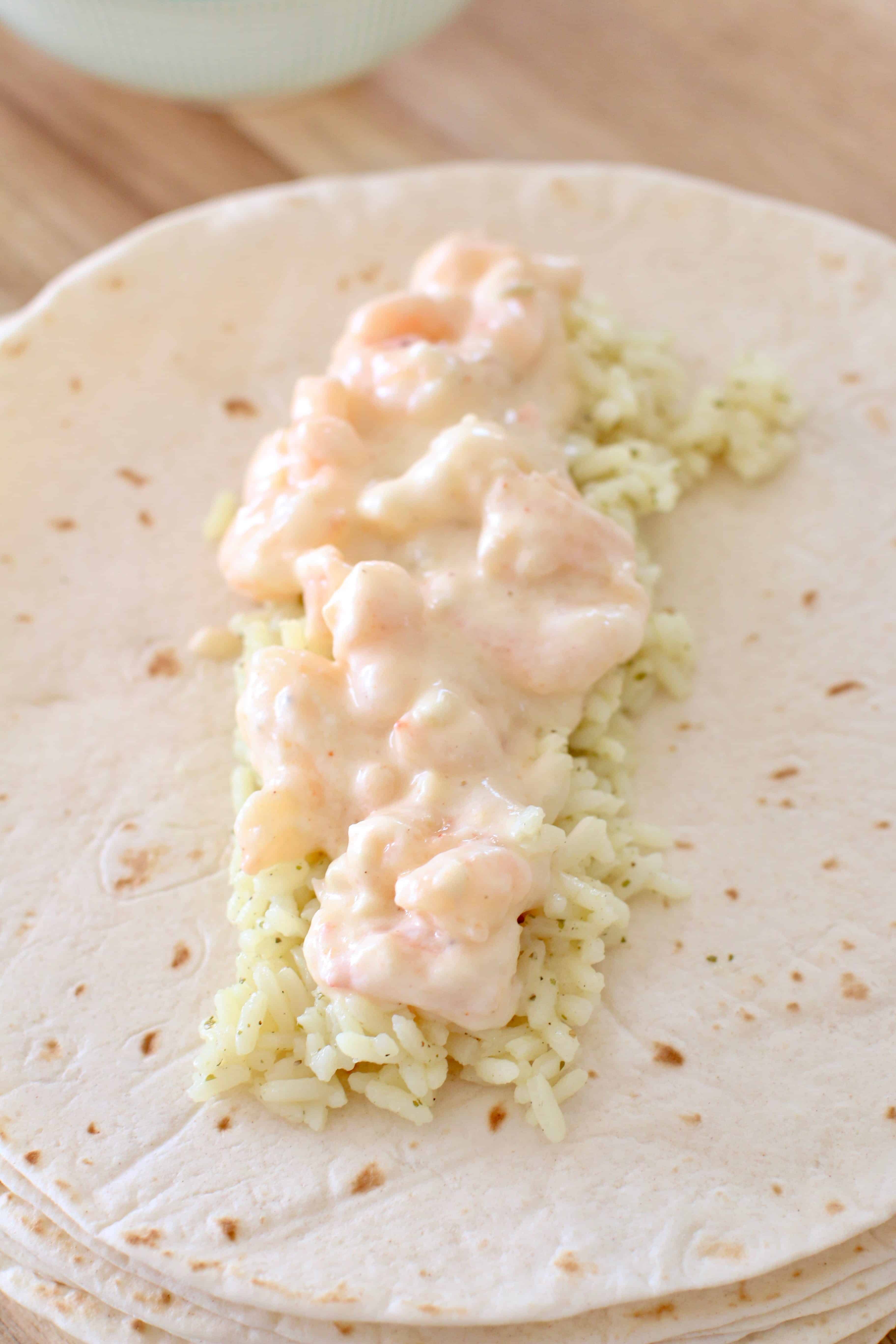 cream and shrimp on top of cilantro lime rice on a flour tortilla.