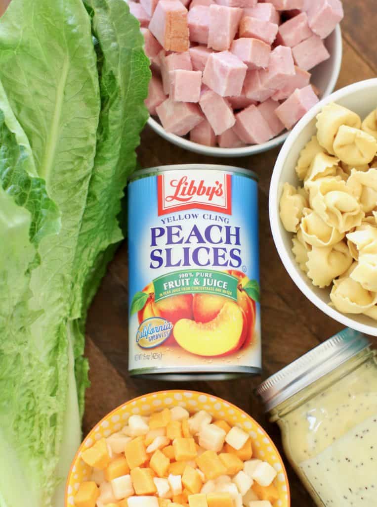 Libby's Peach Slices in fruit juice, romaine lettuce, diced ham, cheese tortellini, cubed cheddar cheese, poppyseed dressing
