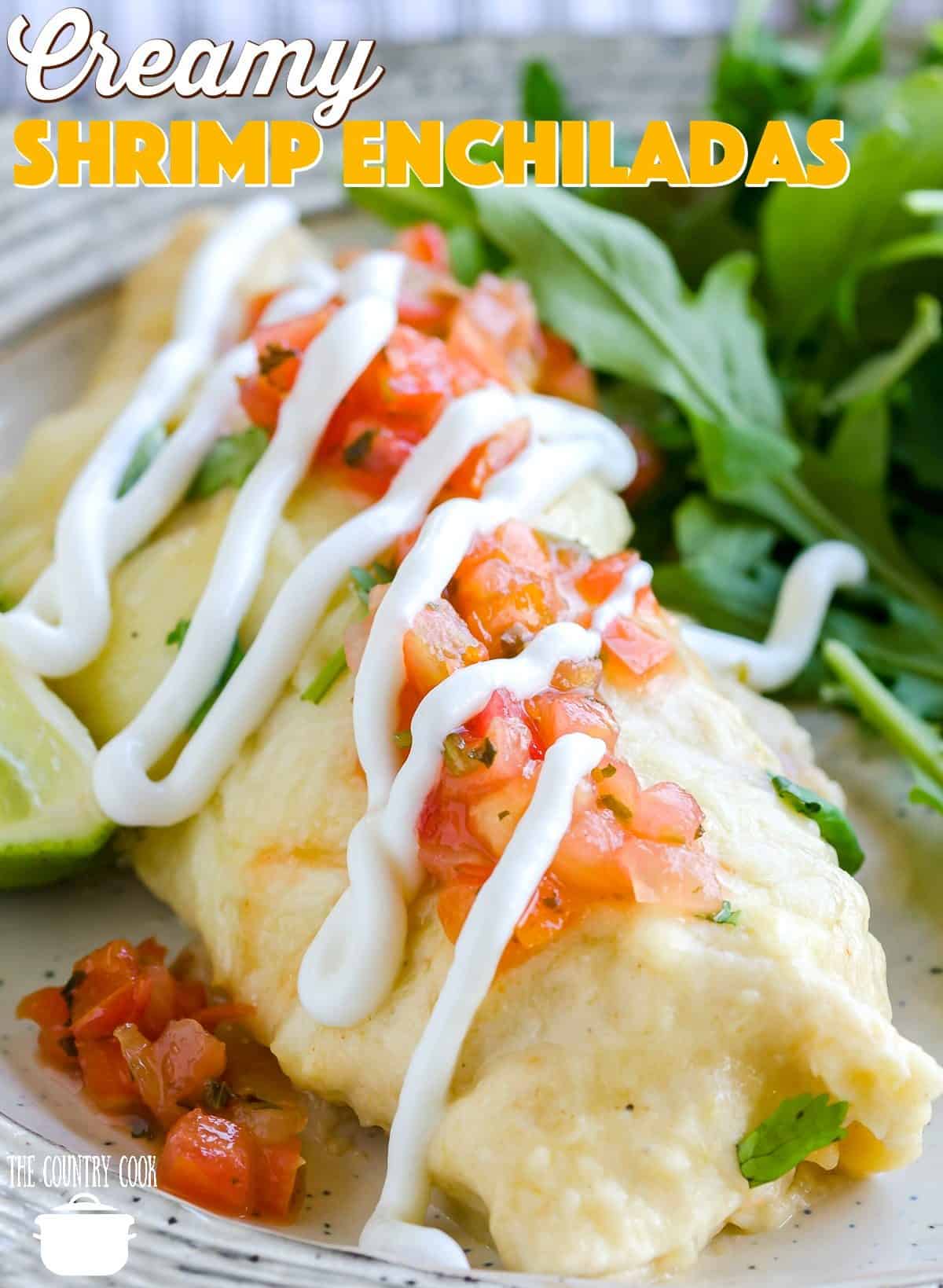 a closeup photo of creamy chrimp enchiladas topped with Pico de Gallo and a drizzle of sour cream.