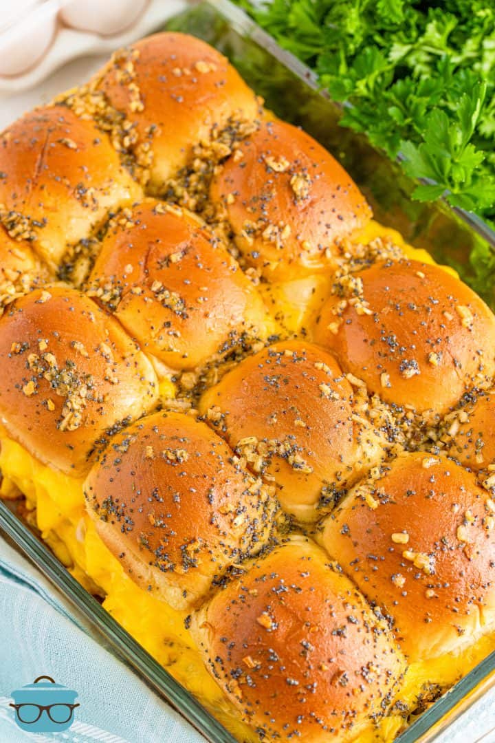 fully baked breakfast sliders in a baking dish with fresh parsley in the background. 