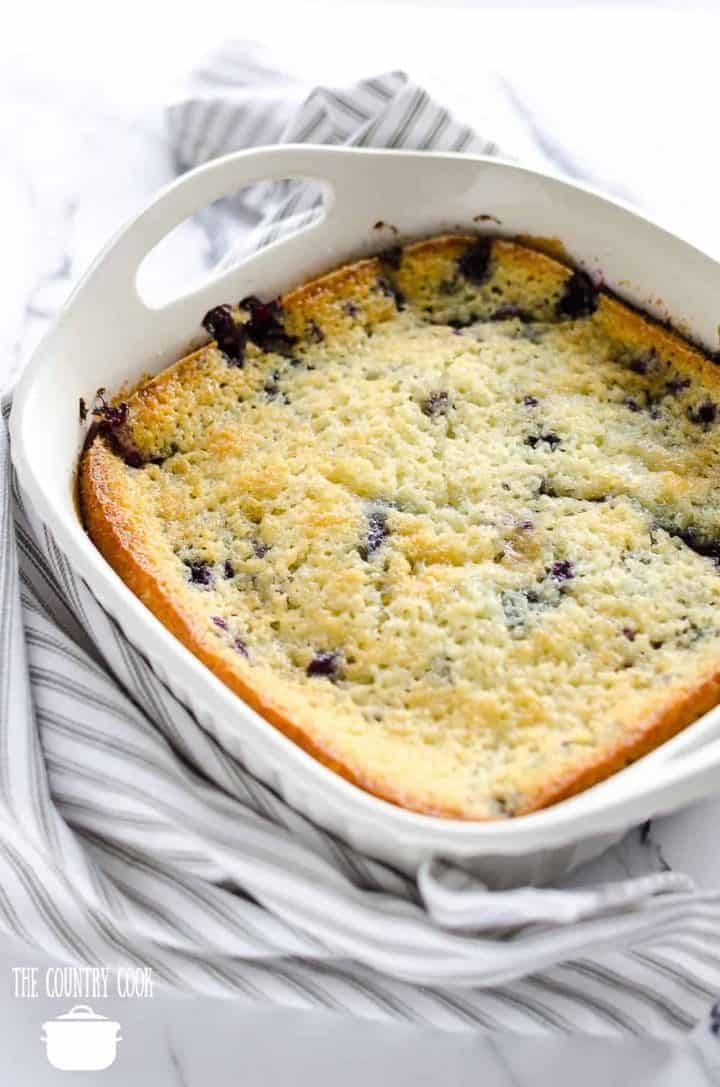 fully baked blueberry cobbler in a white square baking dish with handles.