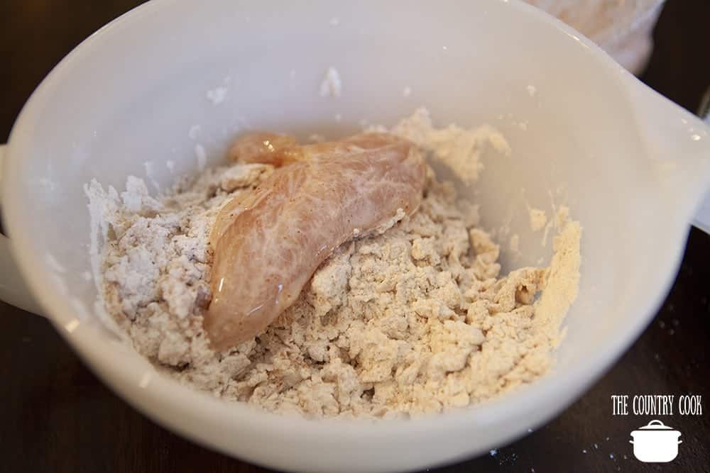coating chicken tenders with flour mixture