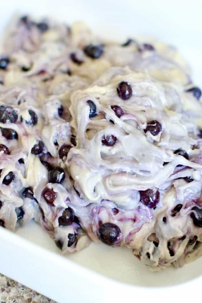 blueberry buckle cake batter spread into a white 9-inch square baking dish