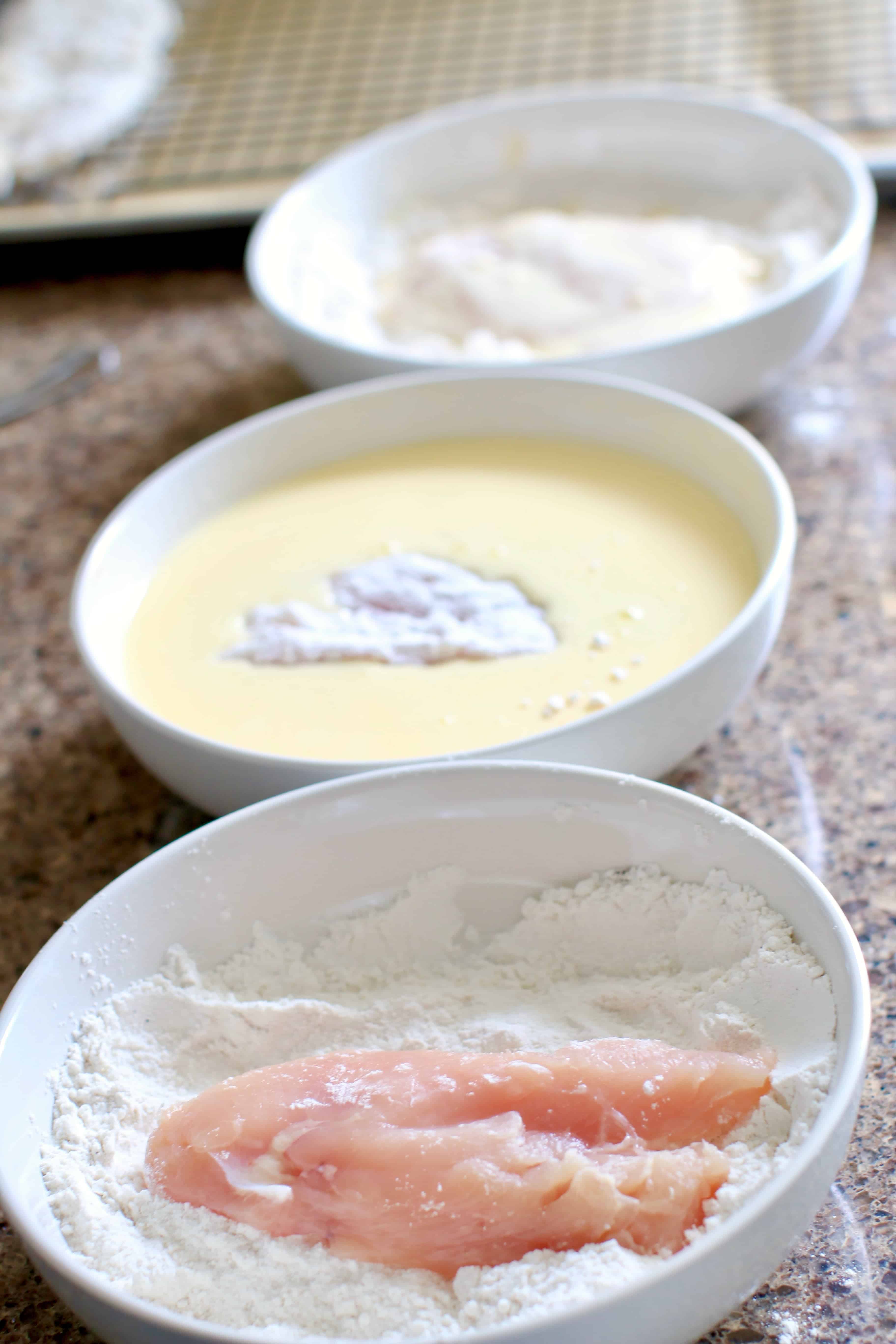 coating chicken breasts in three bowls.