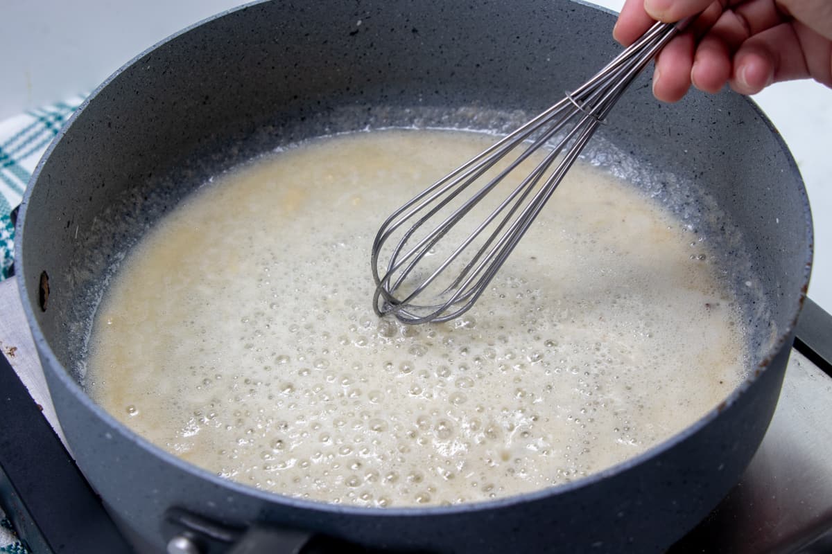 melted butter with flour added to make a roux in a skillet with a whisk.