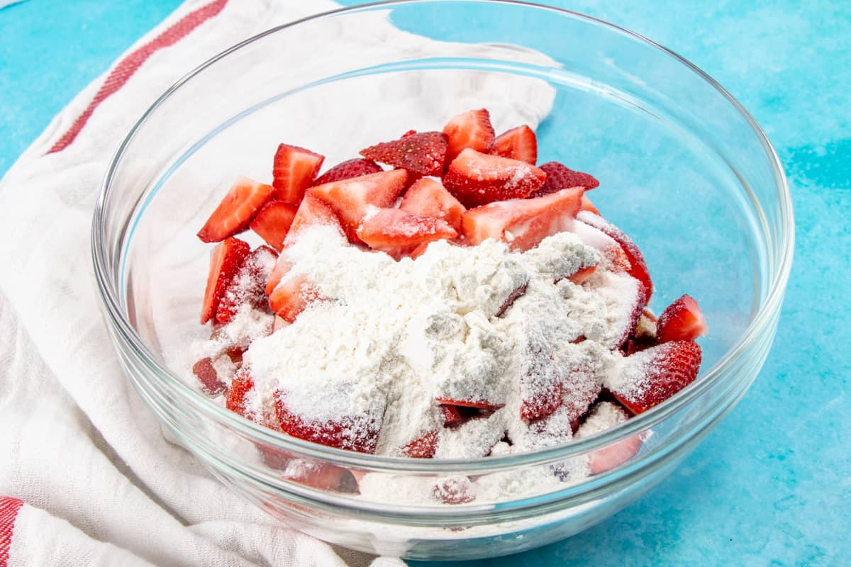 sliced strawberries, chopped rhubarb, sugar, cornstarch and all purpose flour in a bowl.