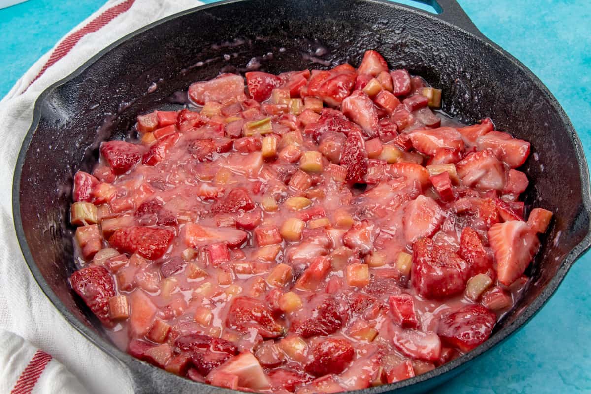 thickened strawberry rhubarb filling in a large cast iron skillet.