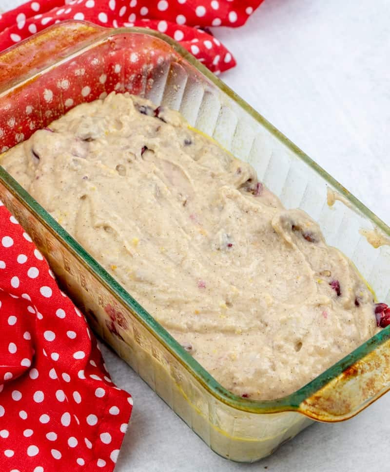 cranberry loaf bread batter poured into a glass baking dish