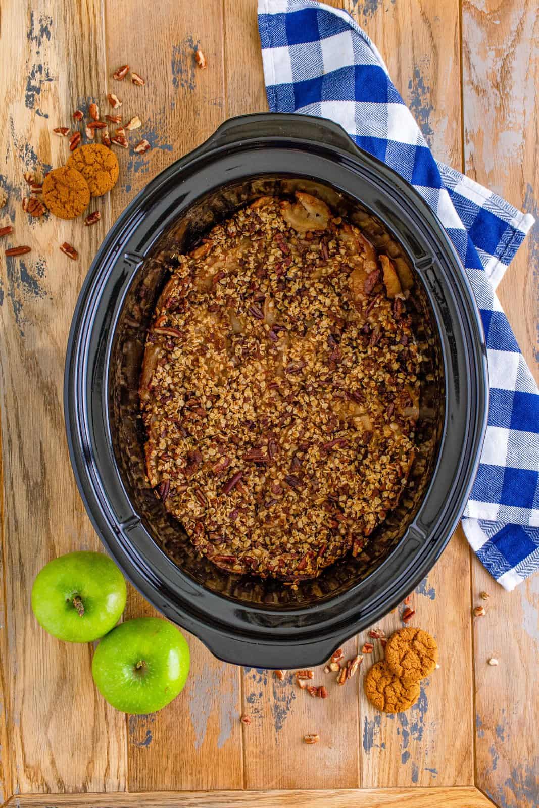 fully cooked apple crisp shown in a slow cooker. 
