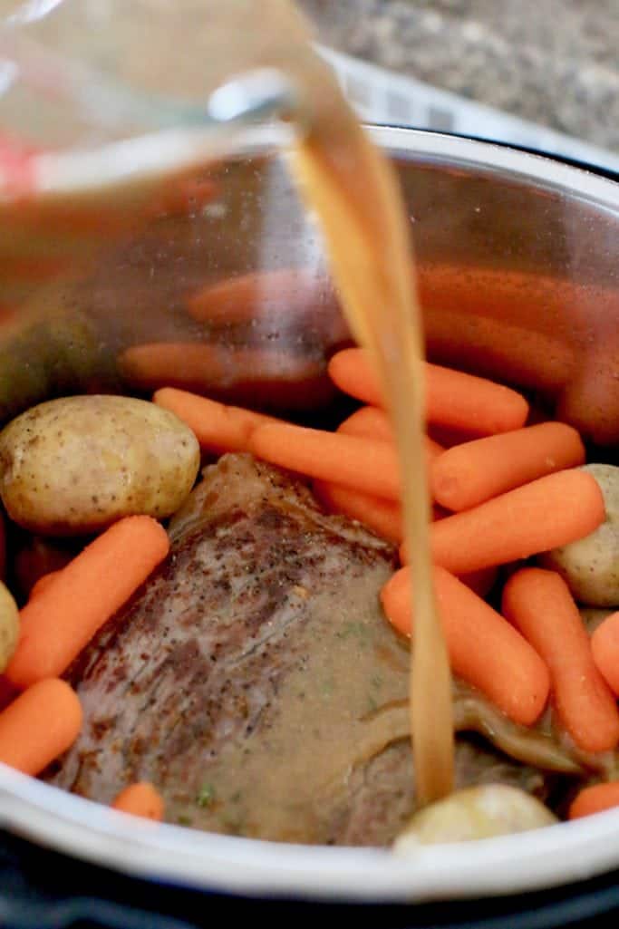 gravy mix poured over beef rump roast, carrots and potatoes in Instant Pot