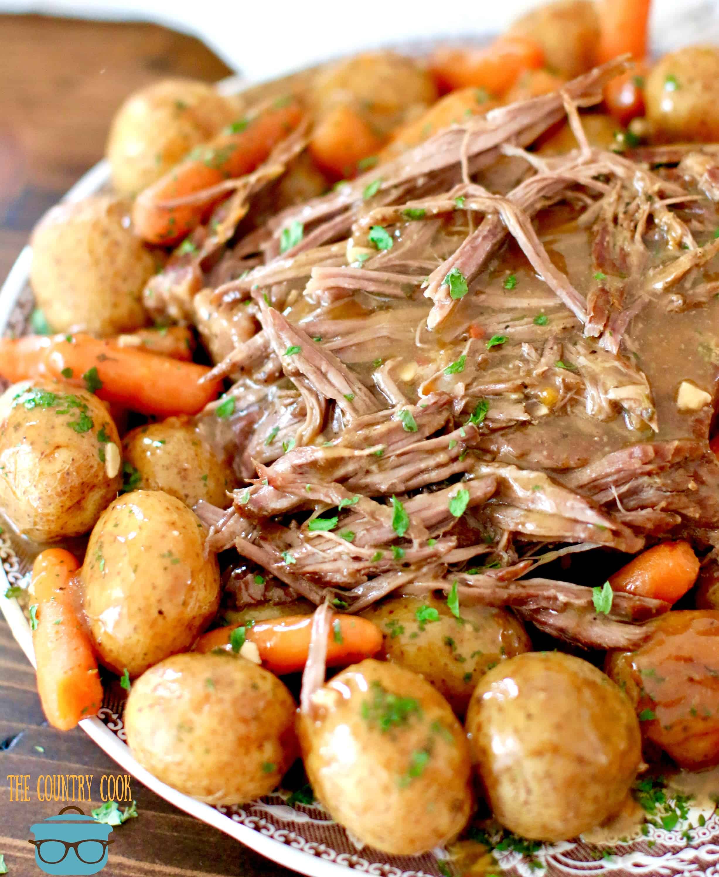 Perfect Instant Pot Roast with gravy shown on a brown and white plate.