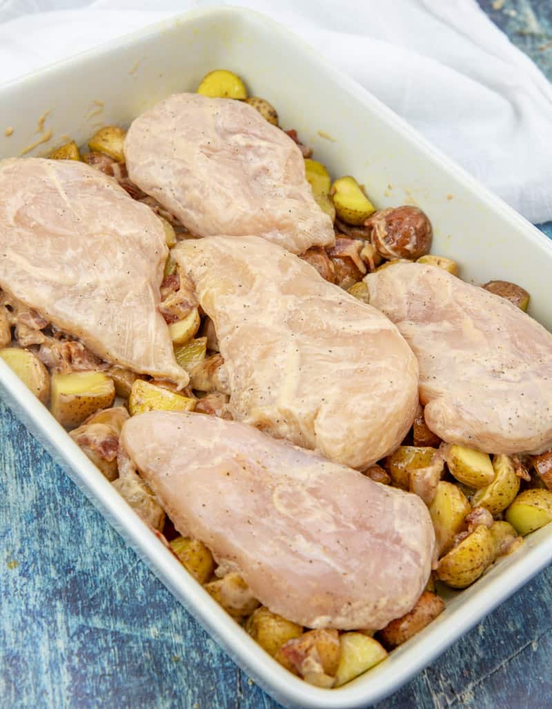 potatoes, bacon, chicken breasts in a baking dish.
