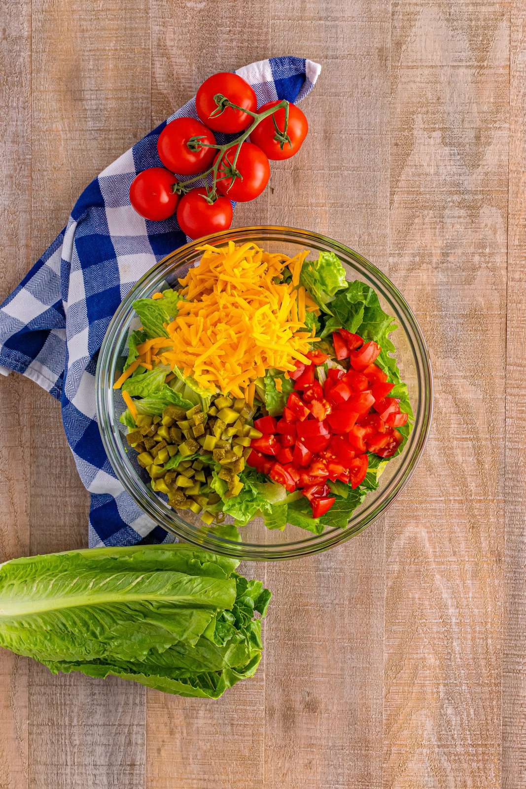 Big Mac salad ingredients shown in a large glass bowl. 