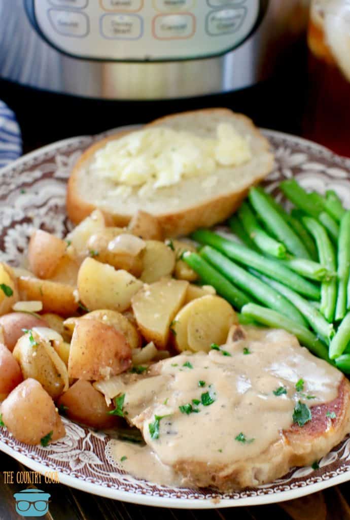 Instant Pot Pork Chops and Gravy and Potatoes shown on a plate with steamed green beans.