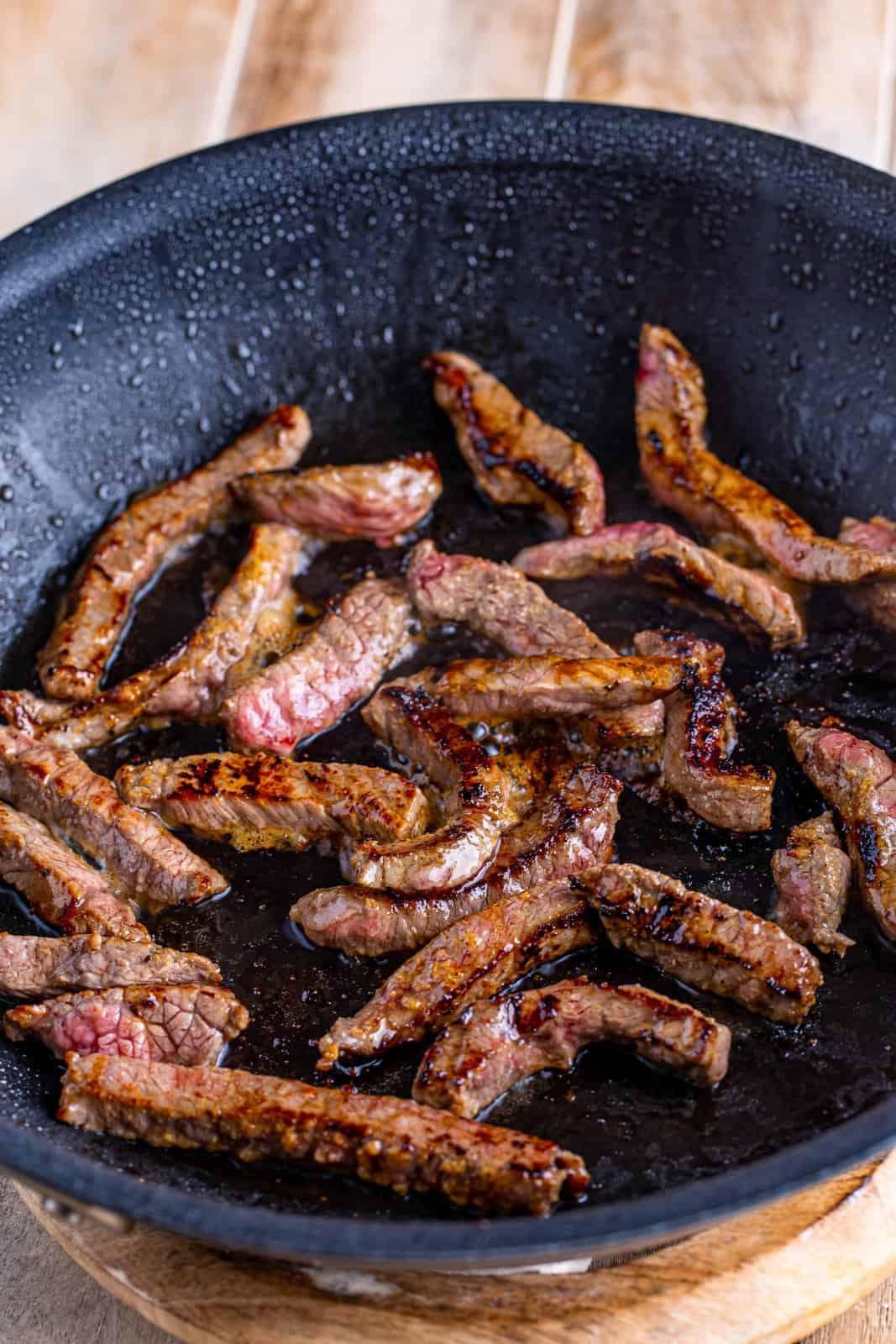 browned beef strips in a skillet. 