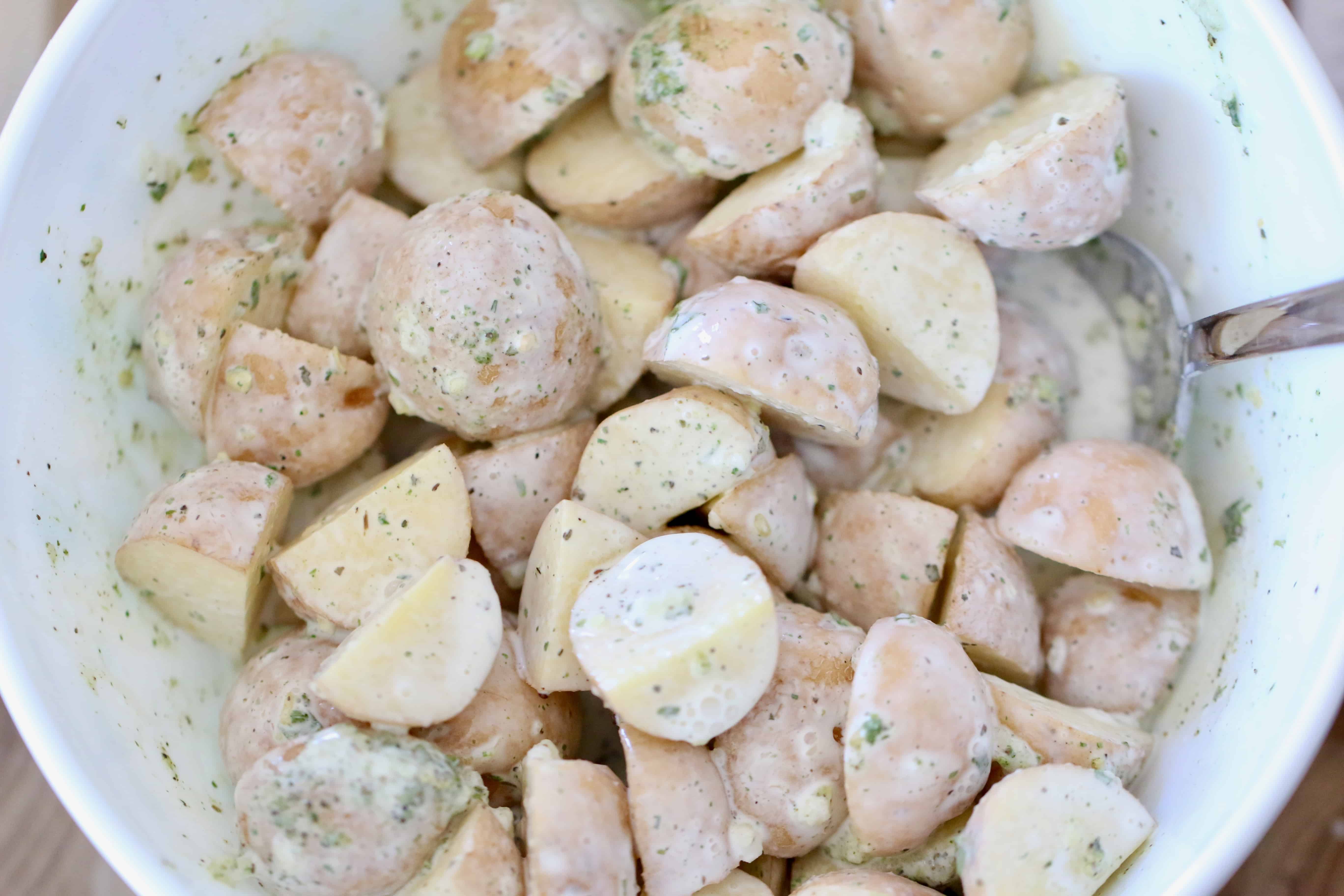 baby potatoes, garlic, onion chive seasoning, ranch seasoning and heavy cream in a bowl.