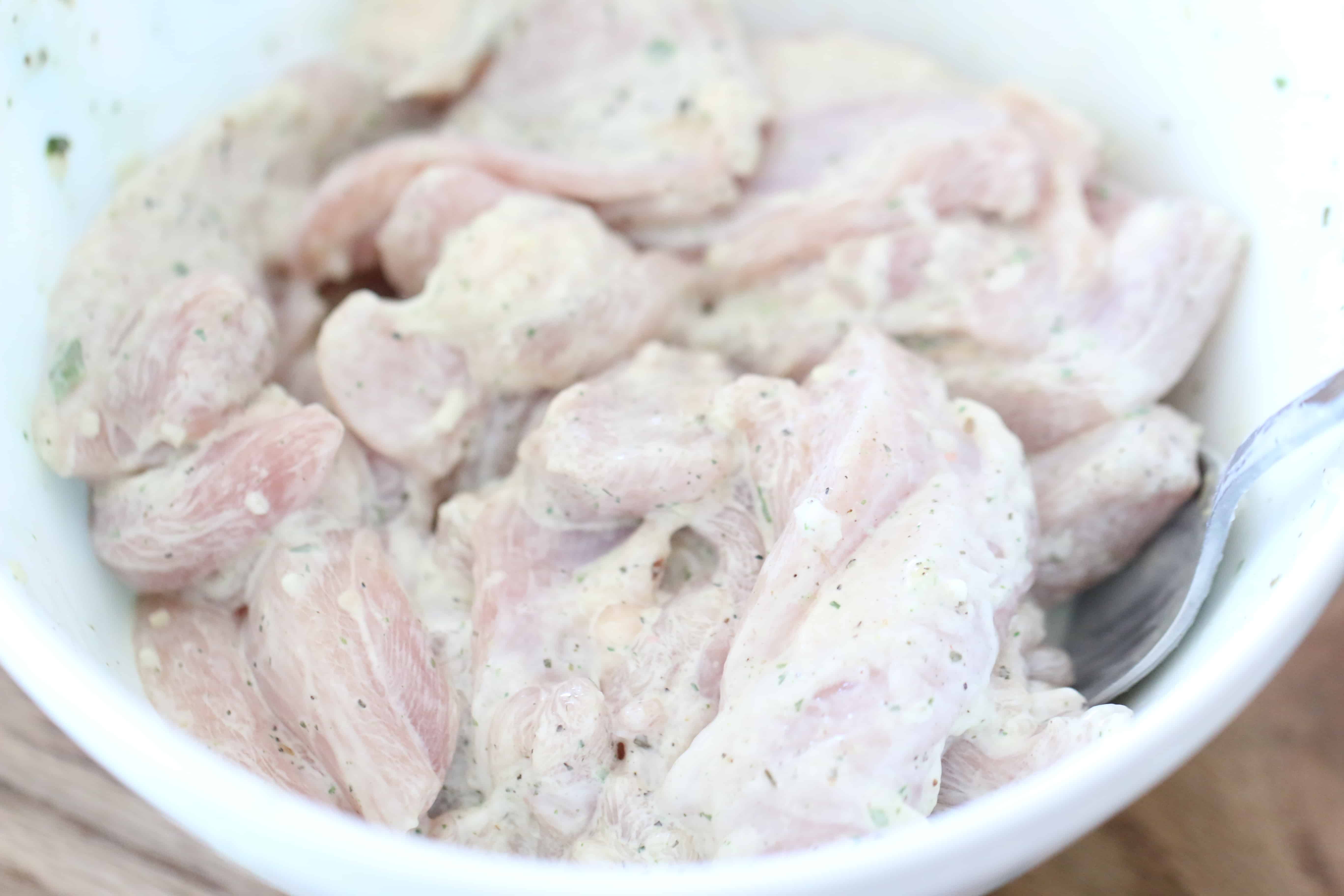 sliced chicken thighs in heavy cream sauce in a bowl.