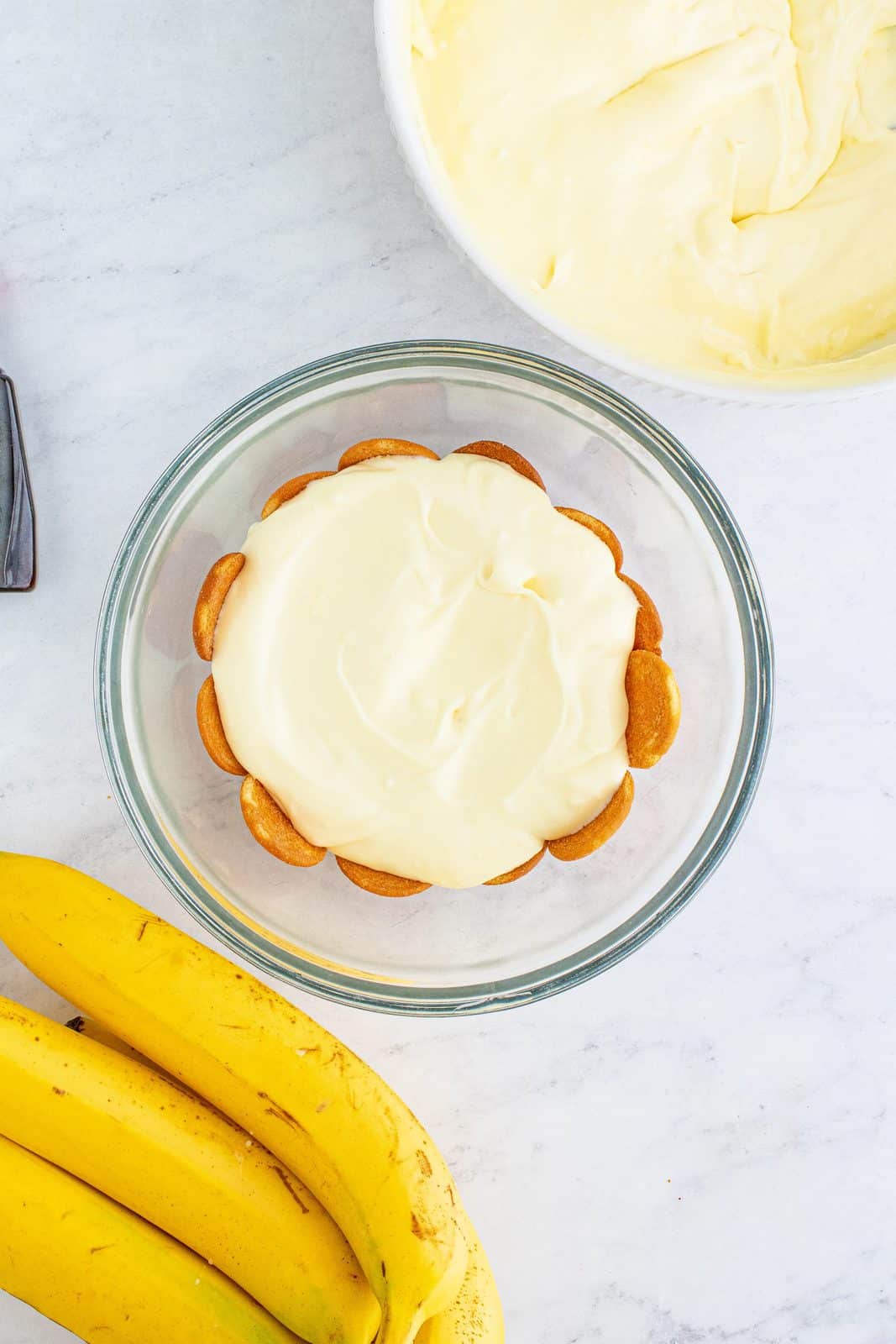 pudding mixture layered on top of bananas and vanilla wafers 