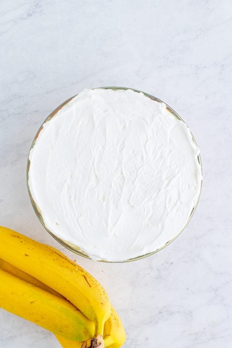 whipped topping spread on top of banana pudding bowl.