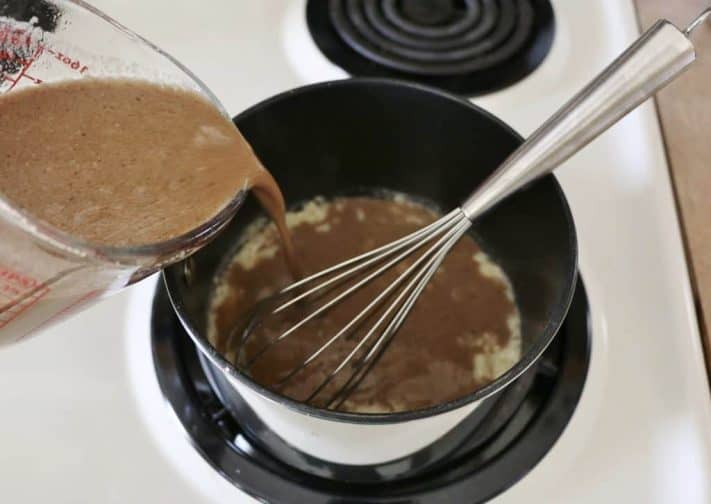 beef broth mixture added to butter and flour mixture in a sauce pan.