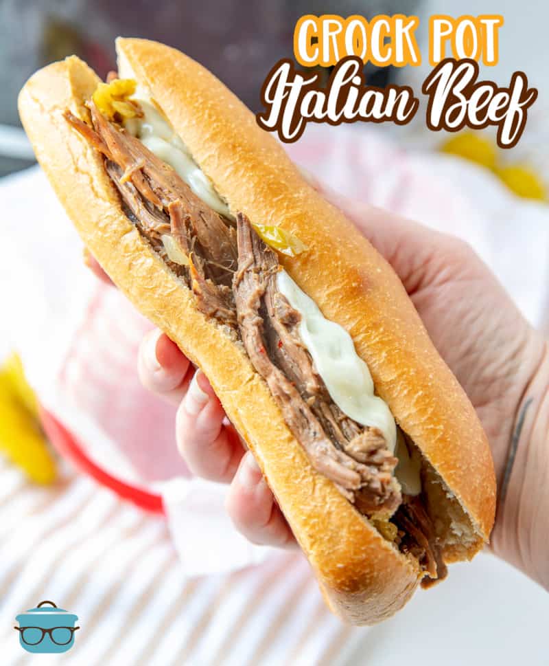 a hand holding up an Italian Beef sandwich.
