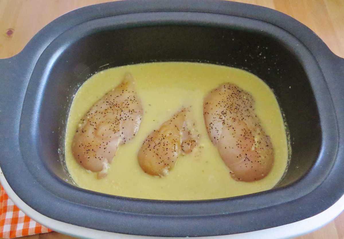 seasoned chicken breasts in chicken gravy in a slow cooker