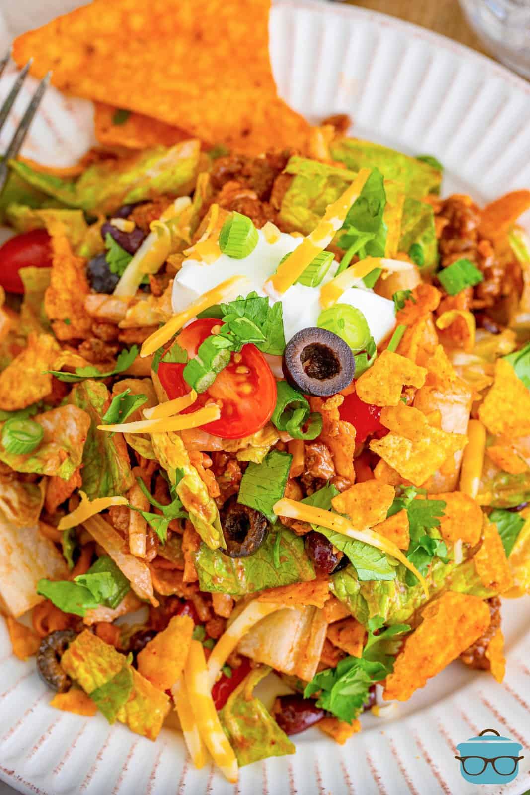bowl of Doritos taco salad topped with a dollop of sour cream.