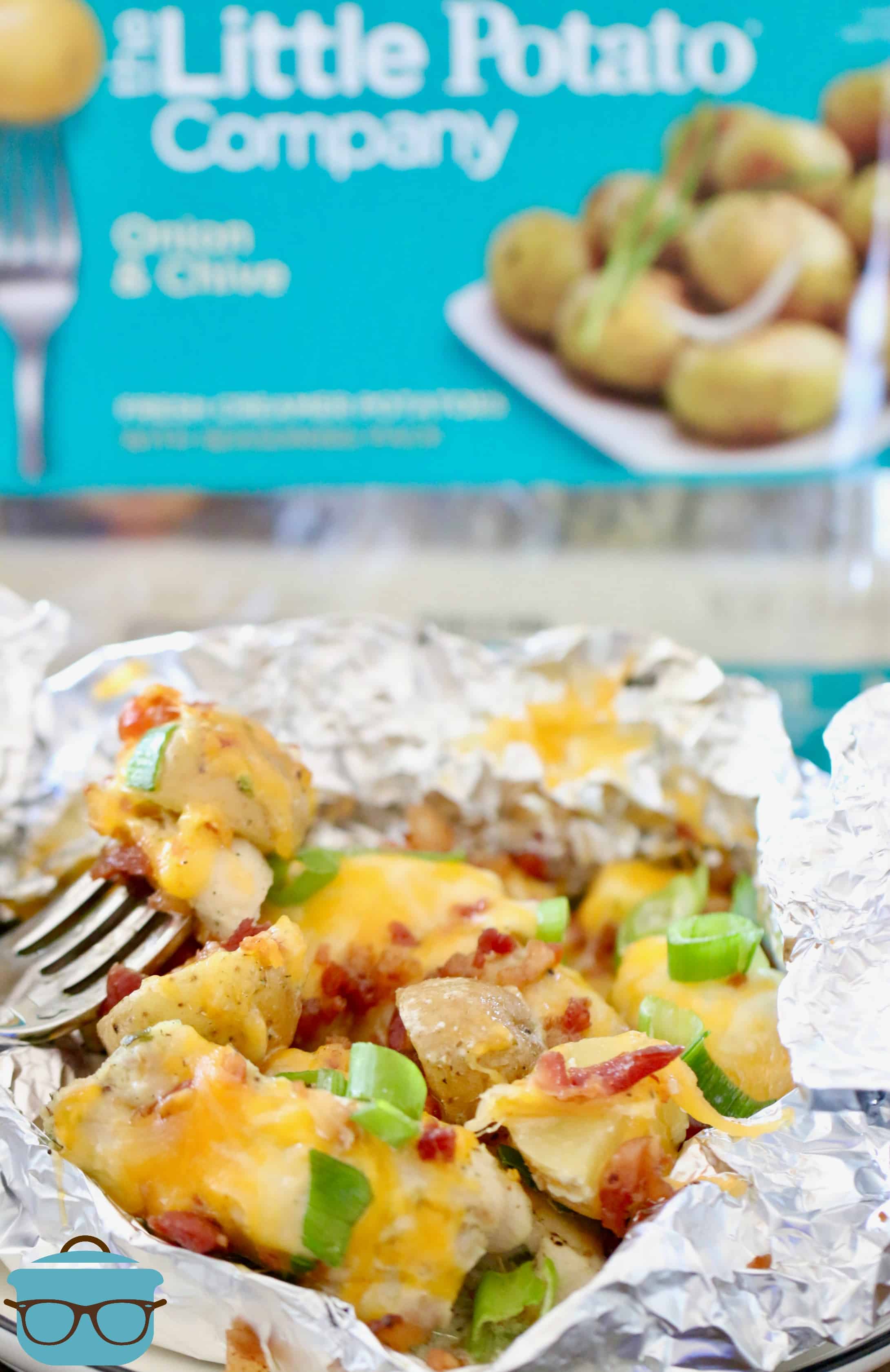 cooked diced potatoes and chicken with melted cheese and bacon inside a foil packet. 
