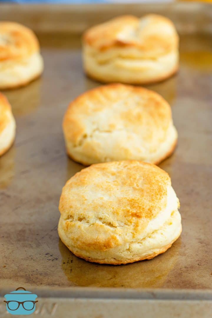 three baked cream biscuits on a cookie sheet.