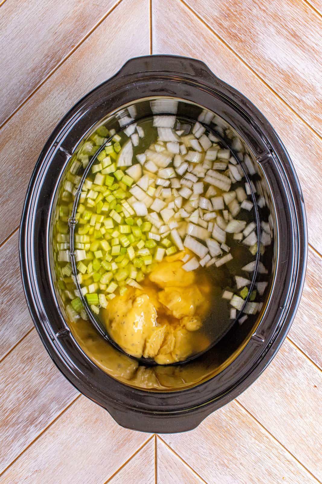 chicken broth, cream of chicken, celery and onion in an oval slow cooker. 