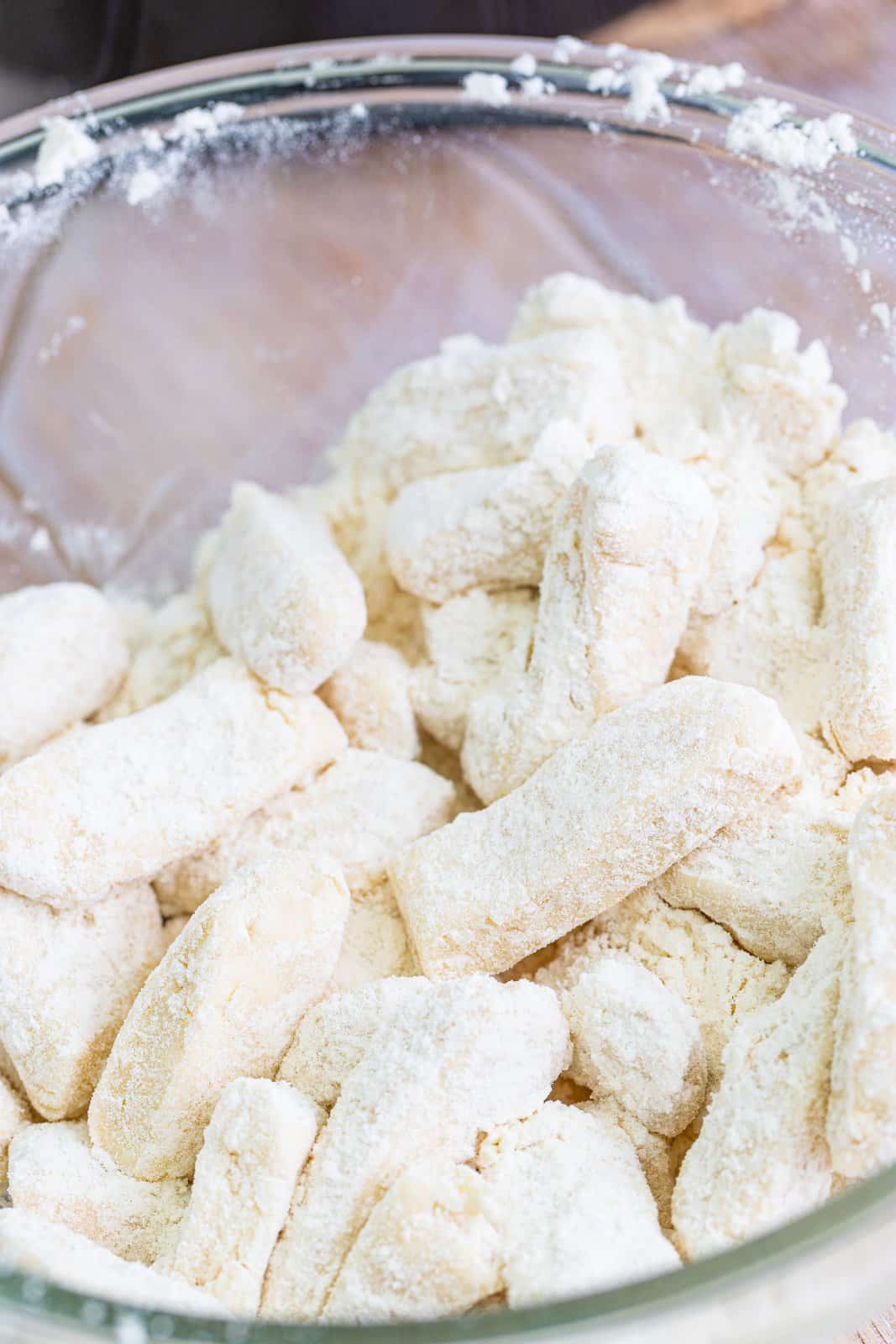 coating biscuits in flour in a bowl.