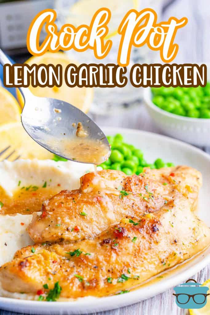 Crock Pot Lemon Garlic Chicken recipe from The Country Cook, two slices of chicken tenders shown on a plate with sauce being poured from a spoon.