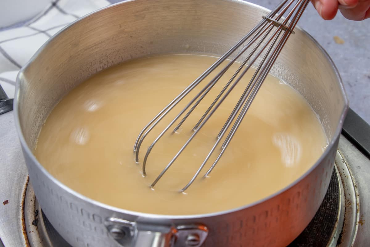 whisking in chicken broth to butter, flour mixture