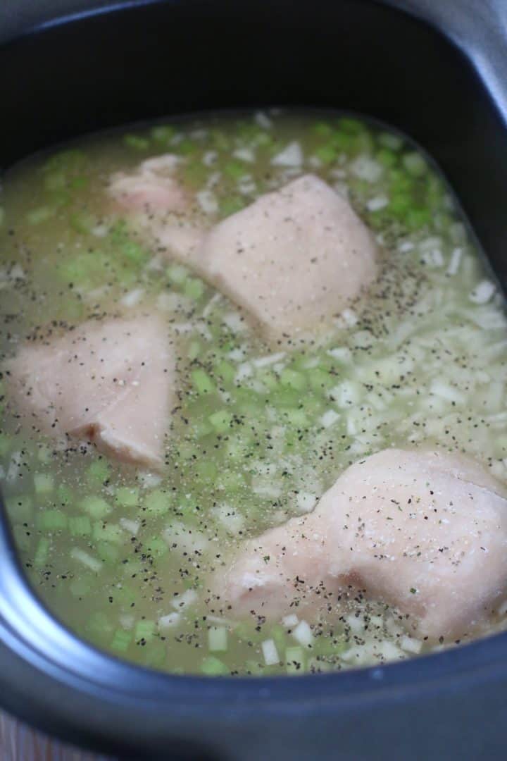 frozen chicken breasts in chicken broth in a slow cooker