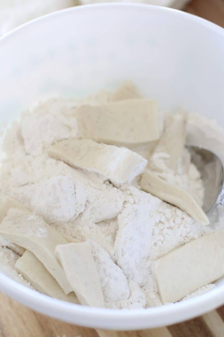 coating biscuit pieces in flour in a bowl