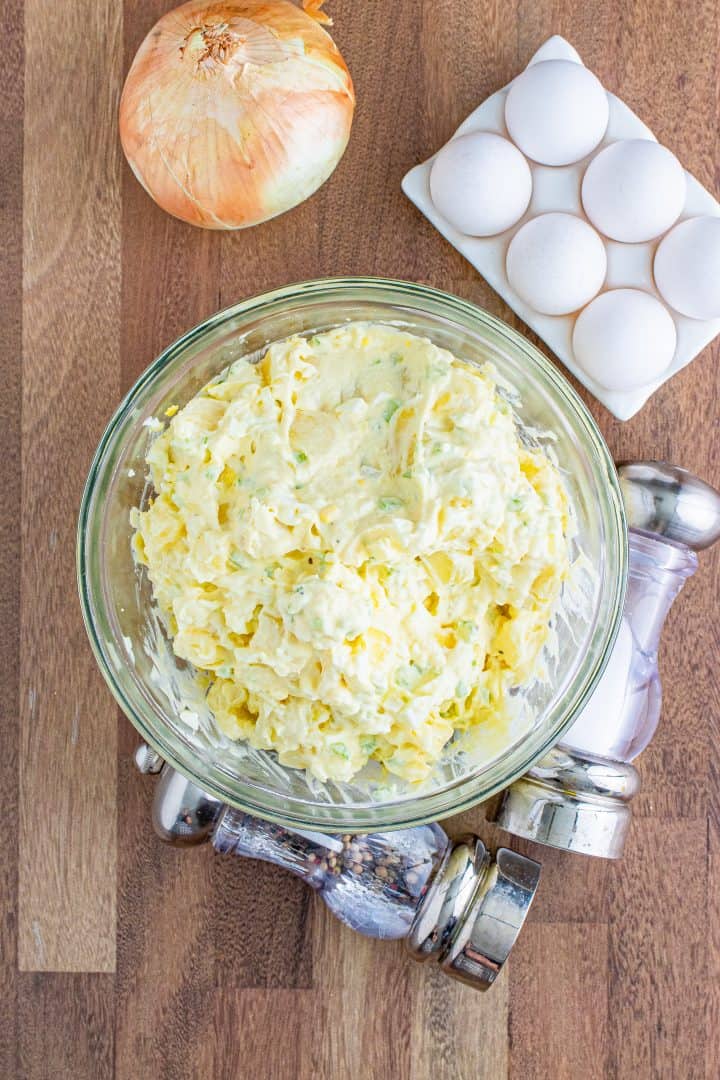 completely stirred mixture of potato salad in a large clear mixing bowl