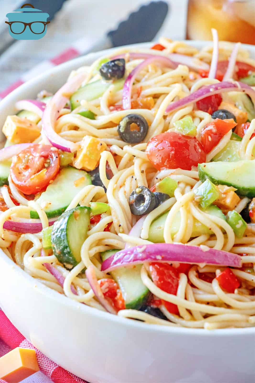 close up photo of spaghetti salad in a large white bowl.