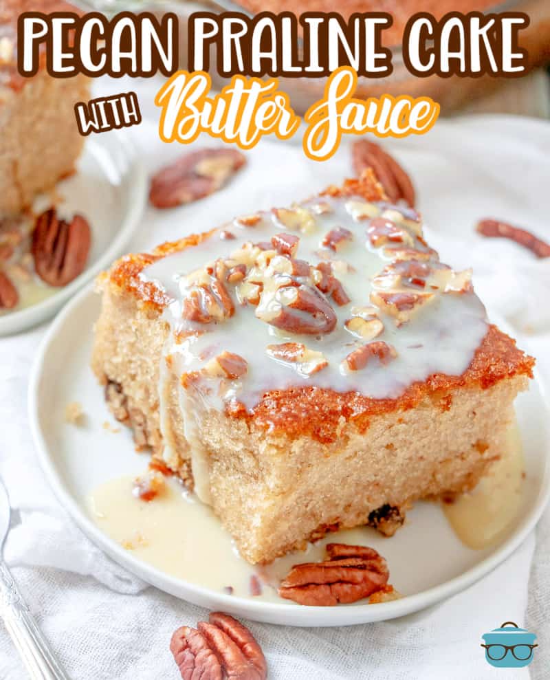a slice of pecan praline cake topped with a sweetened condensed milk sauce and sprinkled with pecans on a small round whit plate. 