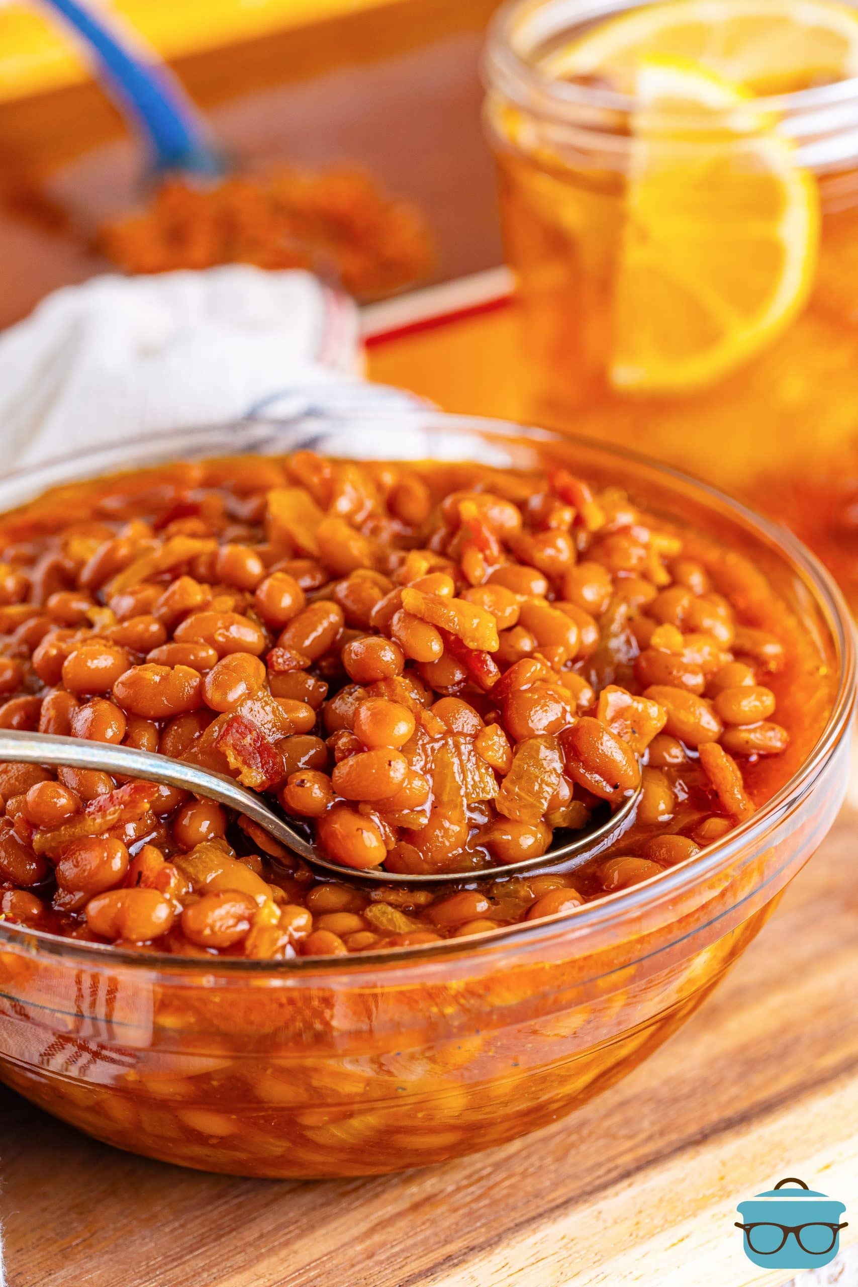 A spoon in a large bowl of Southern Baked Beans.
