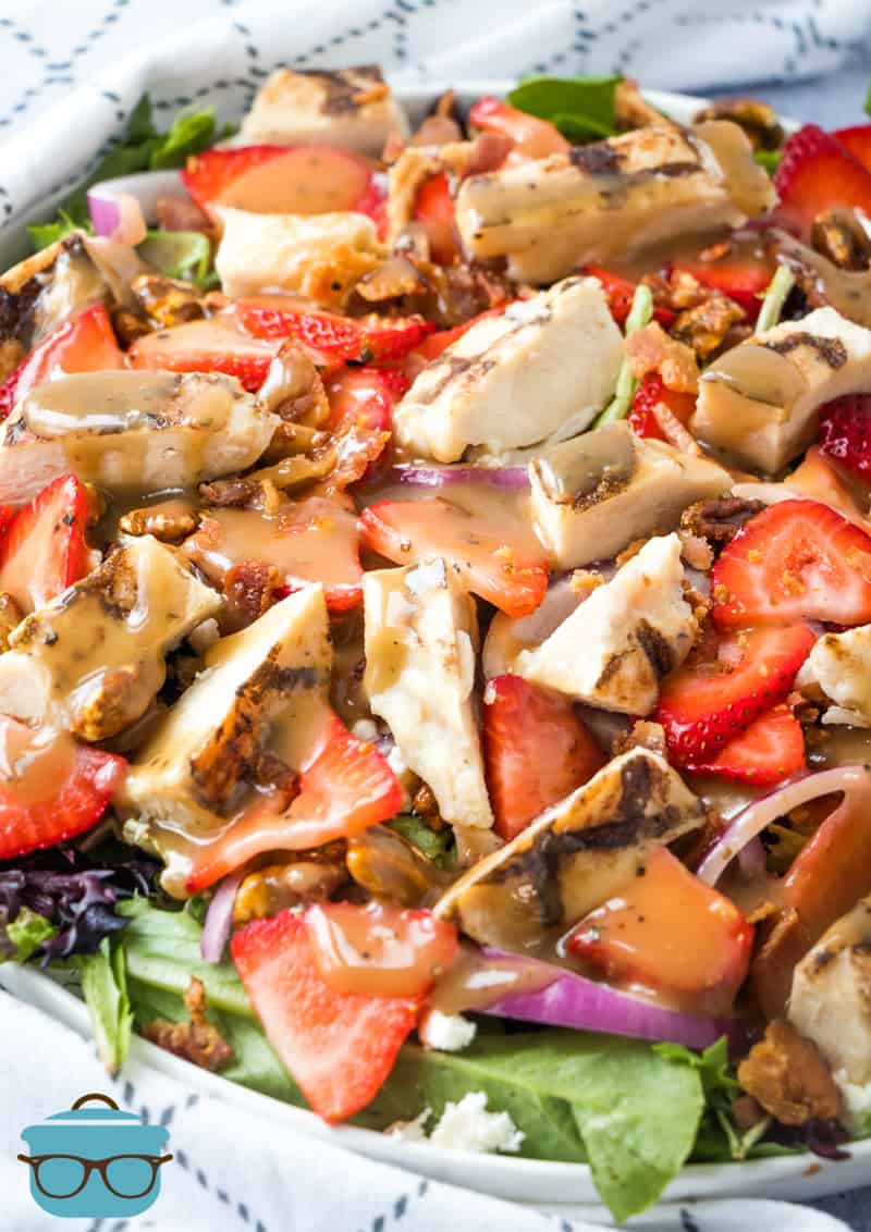 Strawberry Fields Salad shown topped with balsamic dressing and in a white salad bowl.