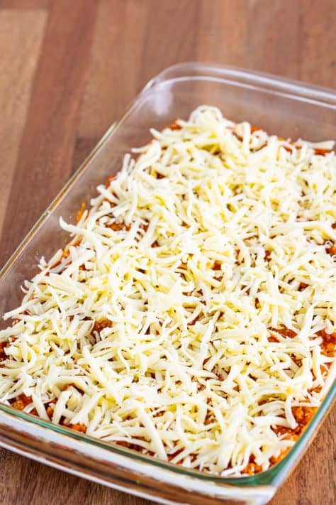 A baking dish with layered unbaked Bubble Up Lasagna in a glass baking dish.
