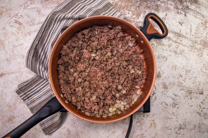 browned and crumbled ground beef with diced on and minced garlic in a large skillet. 