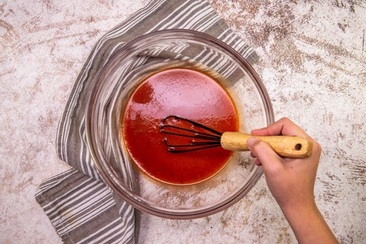 pizza sauce and water whisked together in a clear bowl