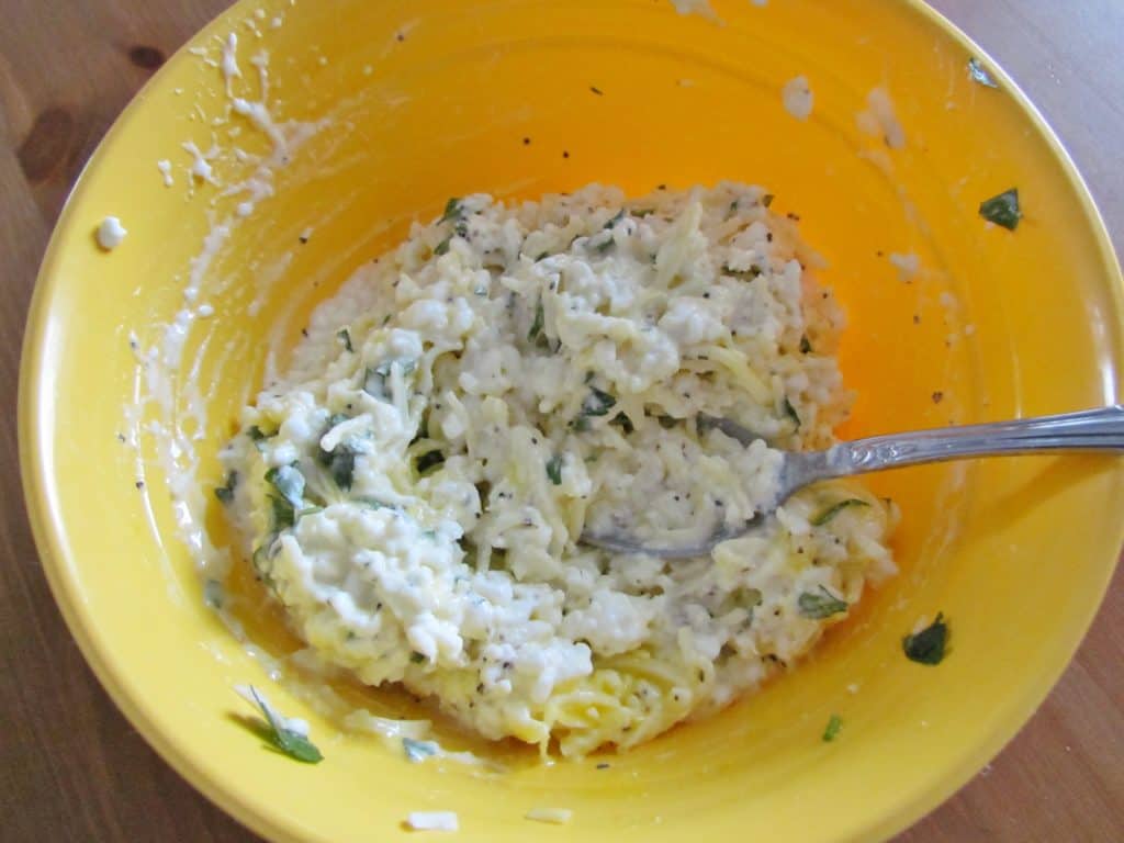 cottage cheese, Parmesan Cheese, egg, mozzarella cheese and parsley stirred together in a bowl.