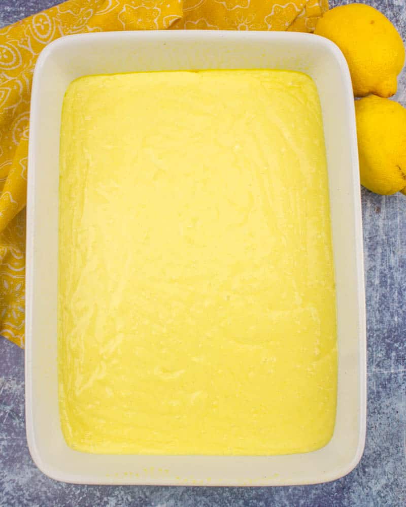 lemon cake mix batter poured into a 9x13 baking dish.