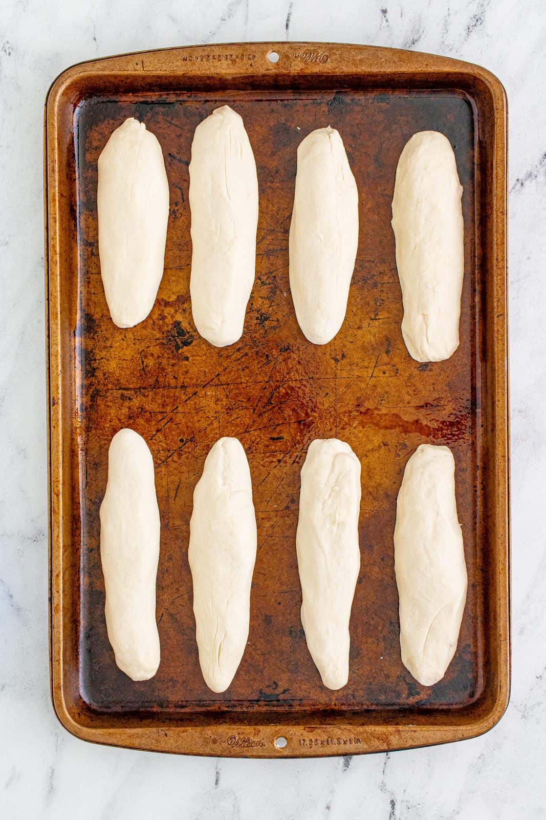 rolled breadsticks on a baking sheet.